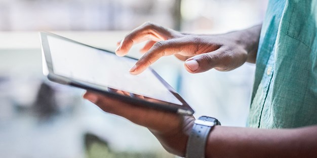 A person clicking on a tablet, photo.