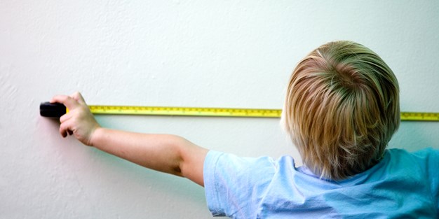 A boy using a tape measure. Photo